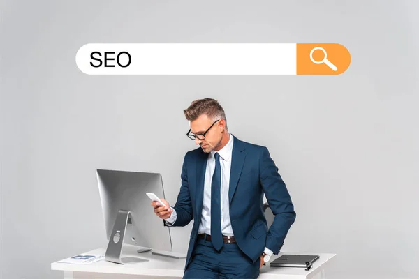 Handsome Businessman Leaning Table Using Smartphone Isolated Grey Seo Search — Stock Photo, Image