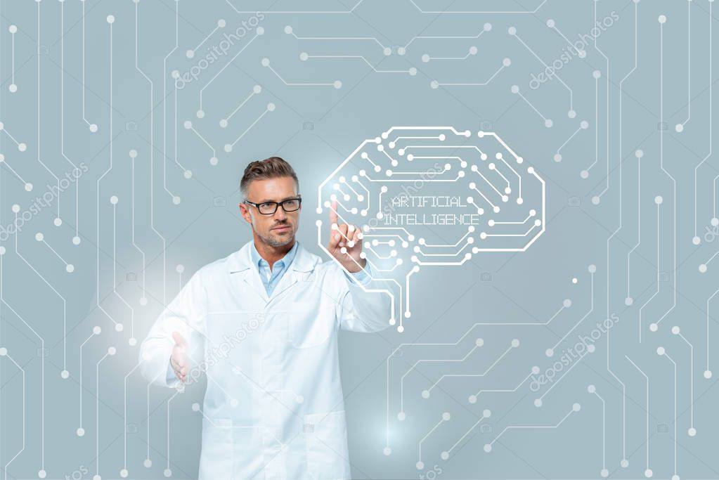 Handsome scientist in glasses touching medical interface with brain isolated on grey, artificial intelligence concept