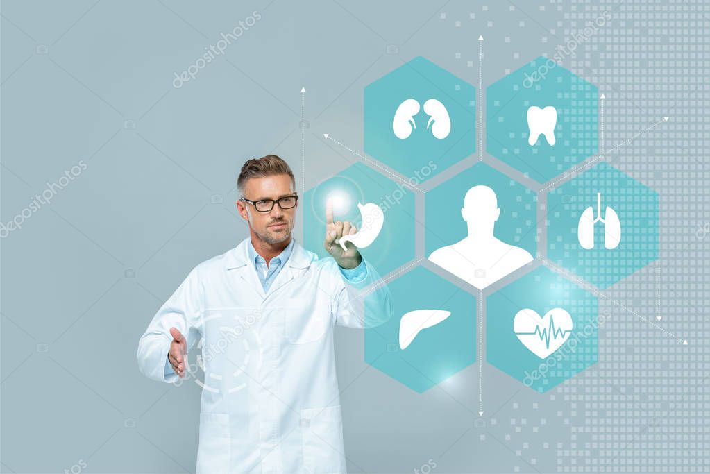 Handsome scientist in glasses touching medical interface isolated on grey, artificial intelligence concept