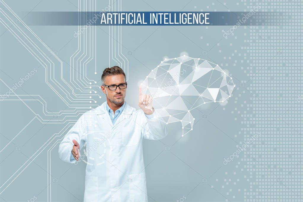 Handsome scientist in glasses touching brain interface isolated on grey, artificial intelligence concept