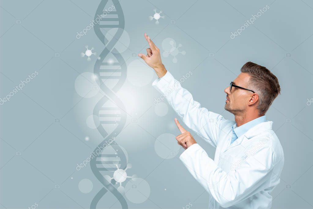 Side view of handsome scientist moving medical interface with dna isolated on grey, artificial intelligence concept