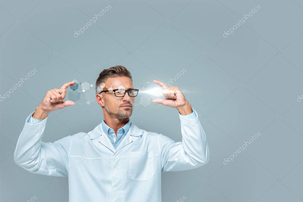 Handsome scientist in glasses holding medical interface isolated on grey, artificial intelligence concept