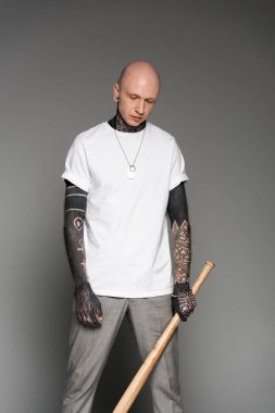 beyzbol sopası tutarak ve gri seyir beyaz t-shirt ciddi dövmeli adam