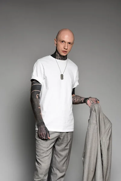 Stylish Bald Tattooed Man Holding Suit Jacket Looking Camera Grey — Stock Photo, Image