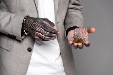 dövmeli adamın gri izole bitcoins tutan takım elbise ceketi giyen kırpılmış atış