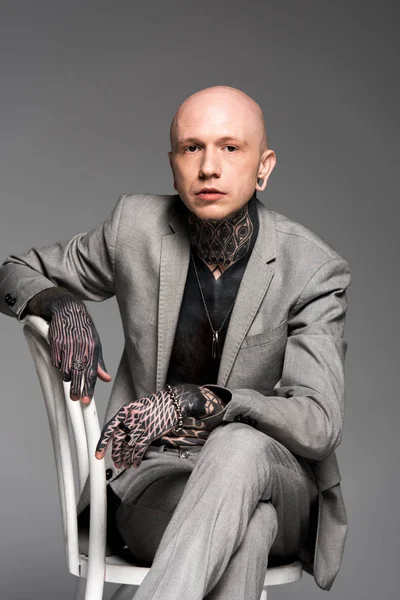 Confident Bald Tattooed Man Suit Sitting Chair Looking Camera Isolated — Stock Photo, Image