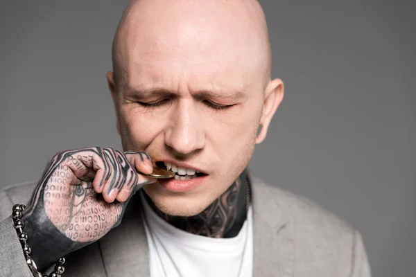 Close Beeld Van Kale Tattooed Man Bijten Bitcoin Geïsoleerd Grijs — Stockfoto