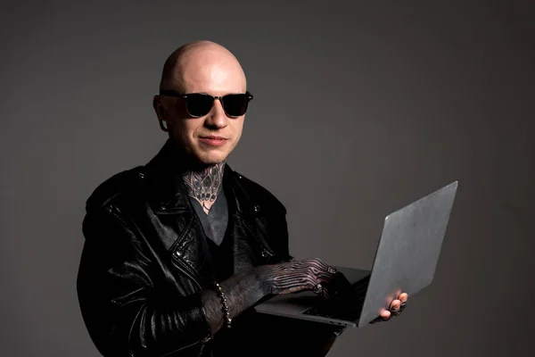 Smiling Tattooed Man Leather Jacket Sunglasses Using Laptop Isolated Grey — Stock Photo, Image