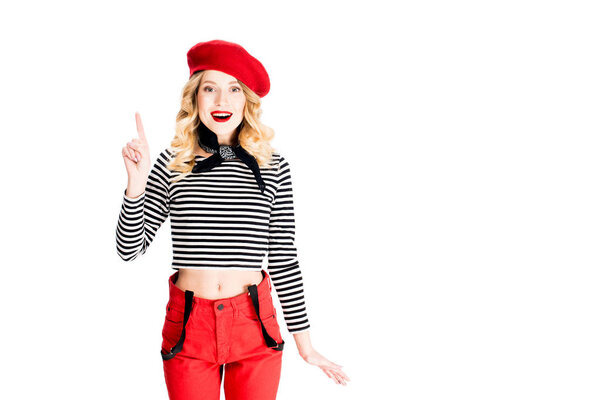 woman in red beret holding finger up while having idea isolated on white
