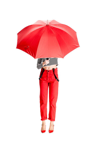 woman holding red umbrella while standing isolated on white 