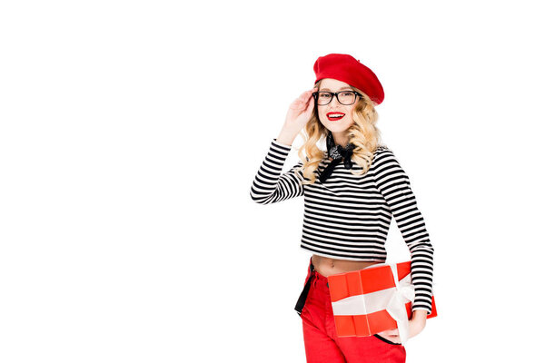 beautiful woman in glasses and red beret holding gift box isolated on white 