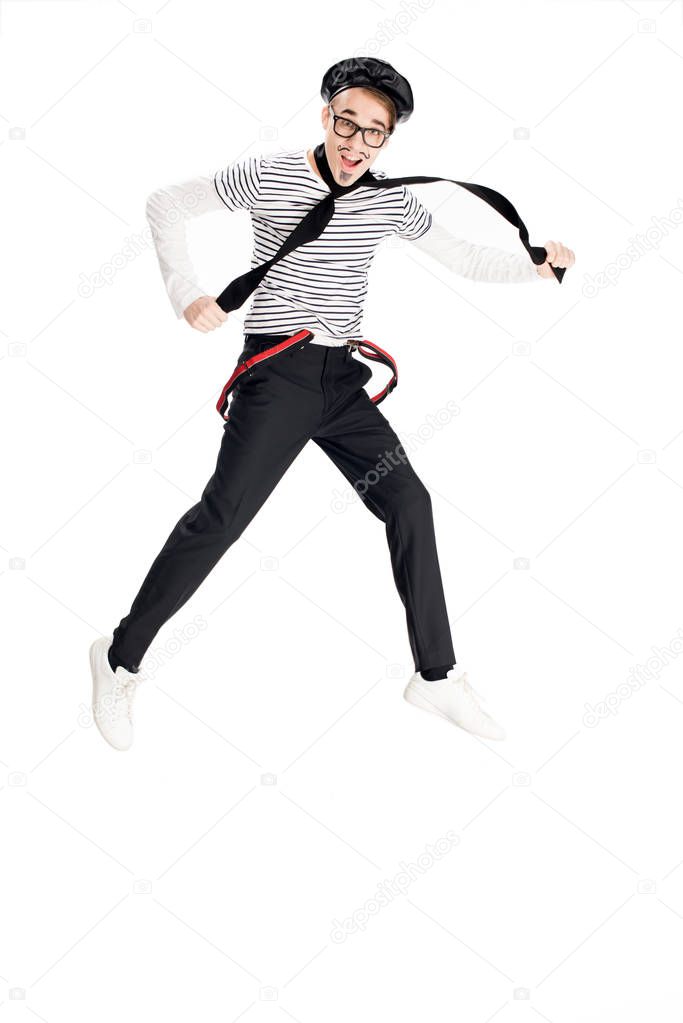 cheerful man in black beret smiling while jumping isolated on white 