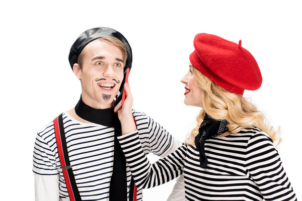 french woman in beret holding smartphone near ear of man isolated on white 