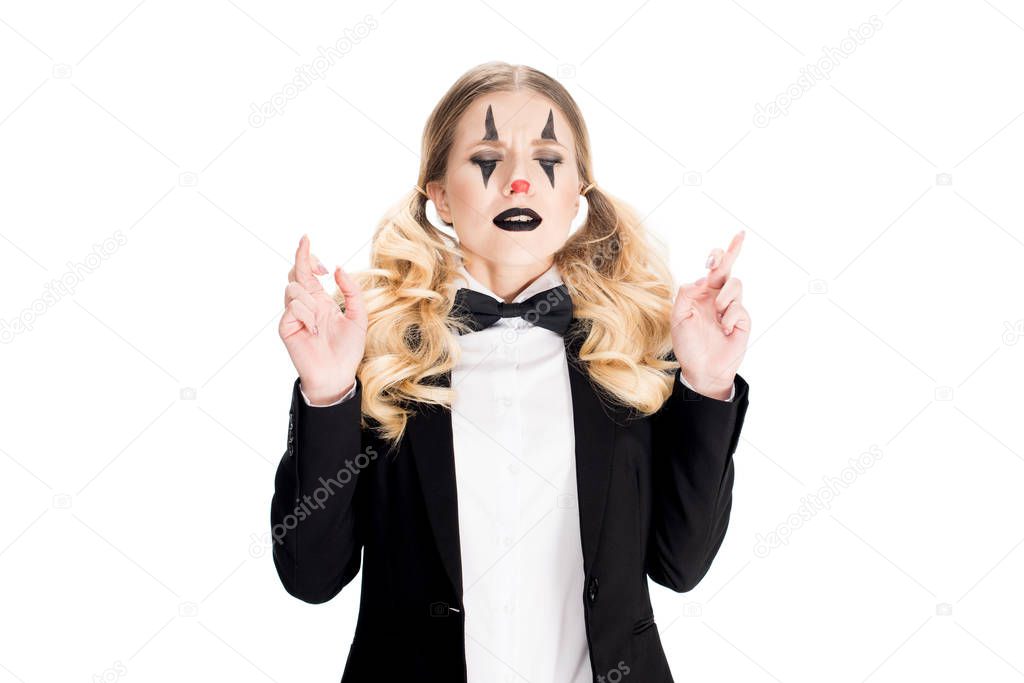  female clown standing with fingers crossed isolated on white 