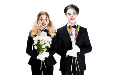 cheerful couple of clowns holding flowers and firecrackers in hands isolated on white  clipart