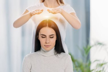 reiki terapi başının üstünde şifa alma kapalı gözlerle huzurlu genç kadın 