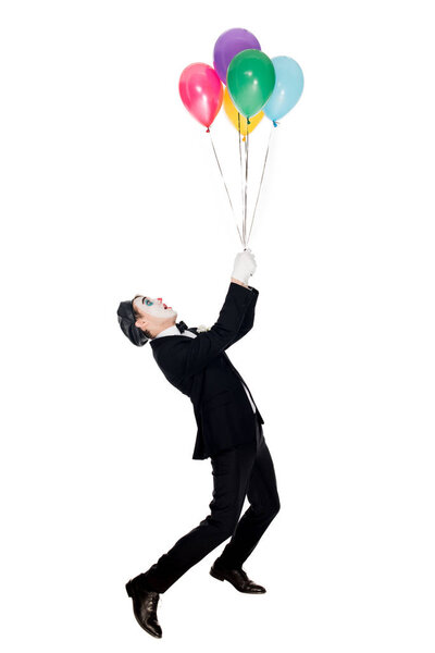 clown in suit and black beret looking at helium balloons isolated on white 