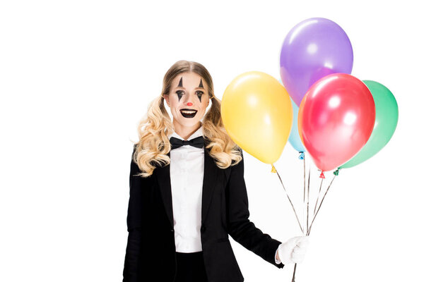 cheerful female clown in suit holding balloons and smiling isolated on white 