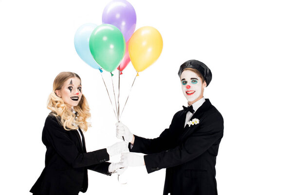 happy clown giving balloons to woman in suit isolated on white 