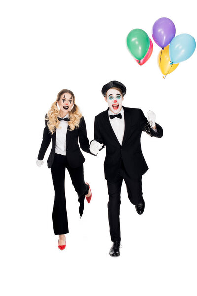 cheerful couple of clowns running with helium balloons isolated on white 