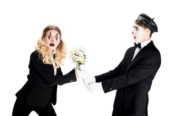 surprised clown giving bouquet to confused woman isolated on white 