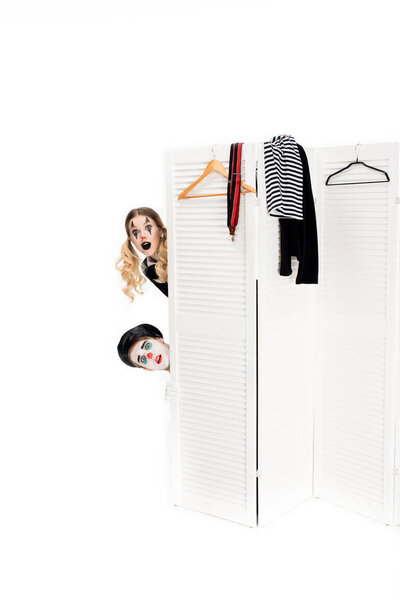 удивленные клоуны, выглядывающие из раздевалки, изолированные на белом
 