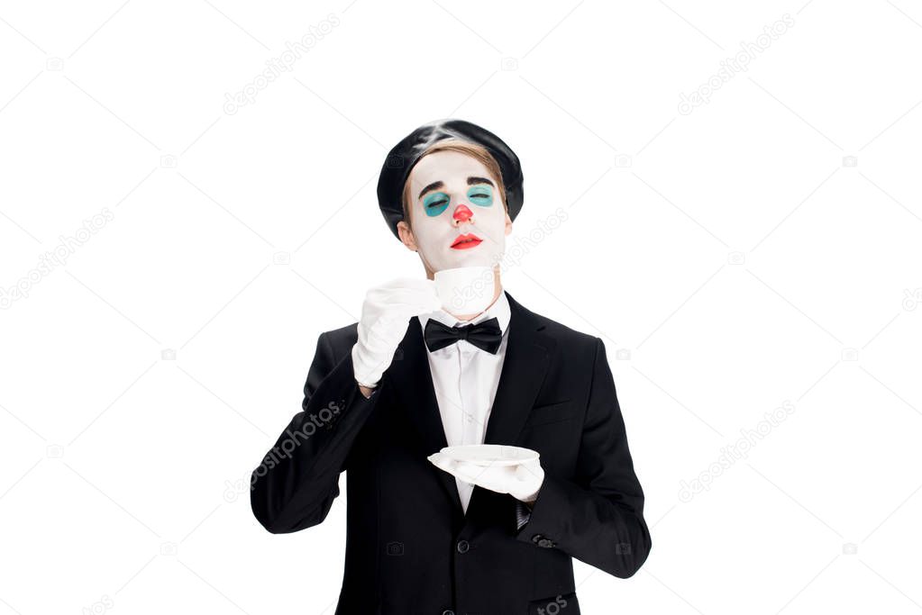 clown standing in suit and smelling cup of coffee isolated on white