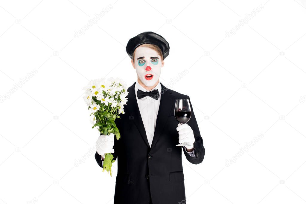 surprised clown holding flowers and glass on wine in hands isolated on white 