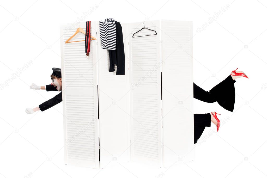 cropped view of clowns looking out from dressing room door isolated on white 