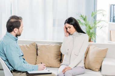 Genç kadın kanepe ve panoya yazma psikiyatrist oturup depresyon ile