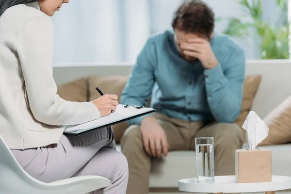 Recortado Disparo Psicoterapeuta Escrito Portapapeles Paciente Molesto Sentado Sofá — Foto de Stock