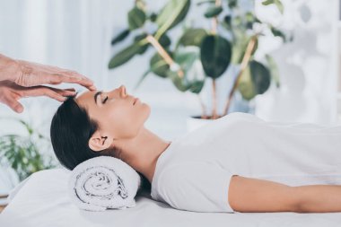 yan görünüm sakin ol genç kadın kapalı gözlerle kafa üzerinde reiki tedavi gören