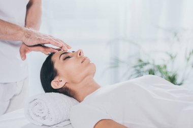 kapalı gözlerle reiki tedavi kafasına sakin genç kadın görüntüsünü kırpılmış