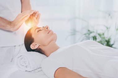 Genç kadının başının üstünde reiki tedavi alan atış kırpılmış 