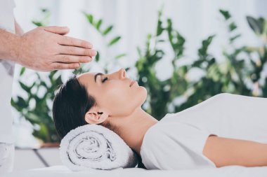Genç kadının başının üstünde reiki tedavi gören atış kırpılmış 