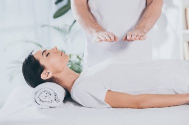 Genç kadın görüntüsünü reiki tedavi gören kapalı gözlerle kırpılmış 