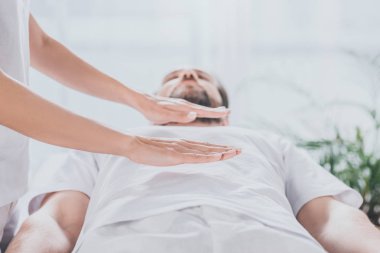 sakallı adam yukarıda mide reiki şifa seansı alan görüntüsünü kırpılmış