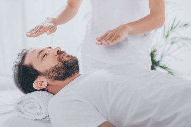 kapalı gözlerle sakallı adam sakinleştirmeye şifacı oturum şifa reiki yapıyor kırpılmış atış