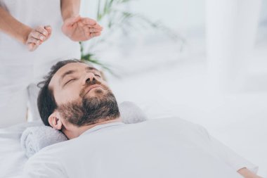 oturum başının üstünde şifa reiki alma kapalı gözlerle sakallı adam sakin
