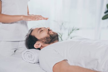 atış sakallı adamın başının üstünde reiki tedavi gören kapalı gözlerle kırpılmış   