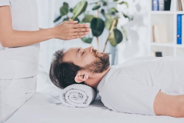 reiki tedavi başının üstünde kapalı gözlerle sakallı adam yan görünüm