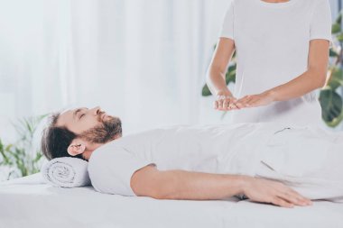 kapalı gözlerle yatarken sakin sakallı adam kırpılmış çekim Masaj tablo ve reiki tedavi gören