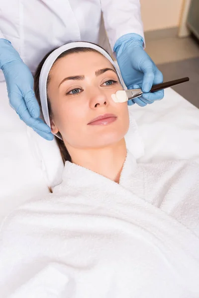 Esteticista Aplicando Máscara Cosmética Rosto Mulher Segurando Escova Cosmética Salão — Fotografia de Stock