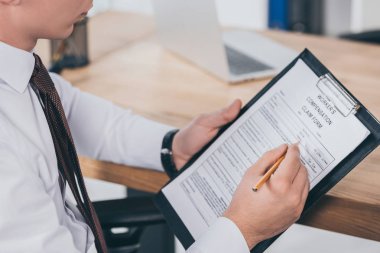 İşyerinde tazminat talep formu doldurarak iş adamı kırpılmış görünümü