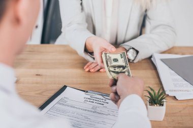 İşyerinde, tazminat kavramı ile kadın para tutan işadamı kısmi görünümü