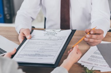İşyerinde kadın Pano tazminat talep formu ve kalem ile veren işadamı kırpılmış görünümü