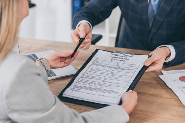 kadın kalem ve form üzerinde ofis, tazminat konsept dizüstü bilgisayar ile tablo için tazminat talep veren işadamı kırpılmış görünümü