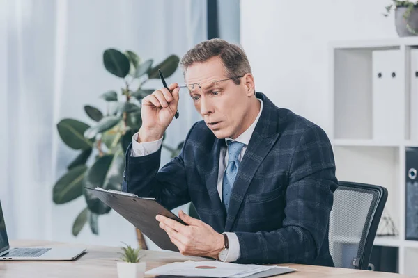 Hombre Negocios Sorprendido Mediana Edad Sentado Mesa Celebración Documentalista Lectura — Foto de Stock