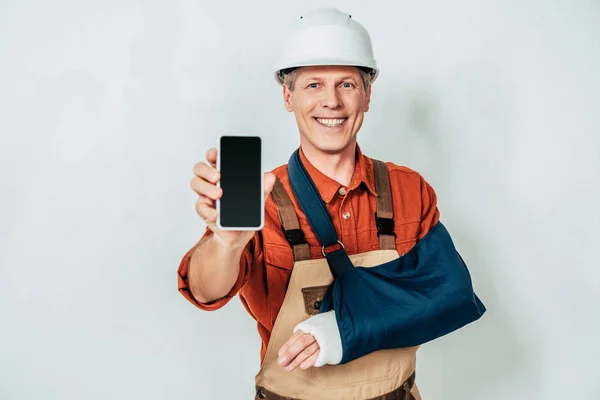 Reparador Con Vendaje Brazo Que Muestra Teléfono Inteligente Fondo Blanco — Foto de Stock