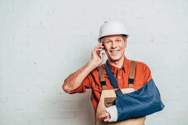 Repairman Arm Bandage Talking Smartphone White Textured Background — Stock Photo, Image